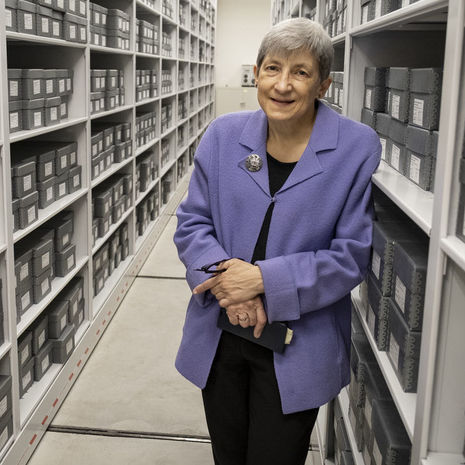 Image of Margery Sly in front of rows of gray boxes.