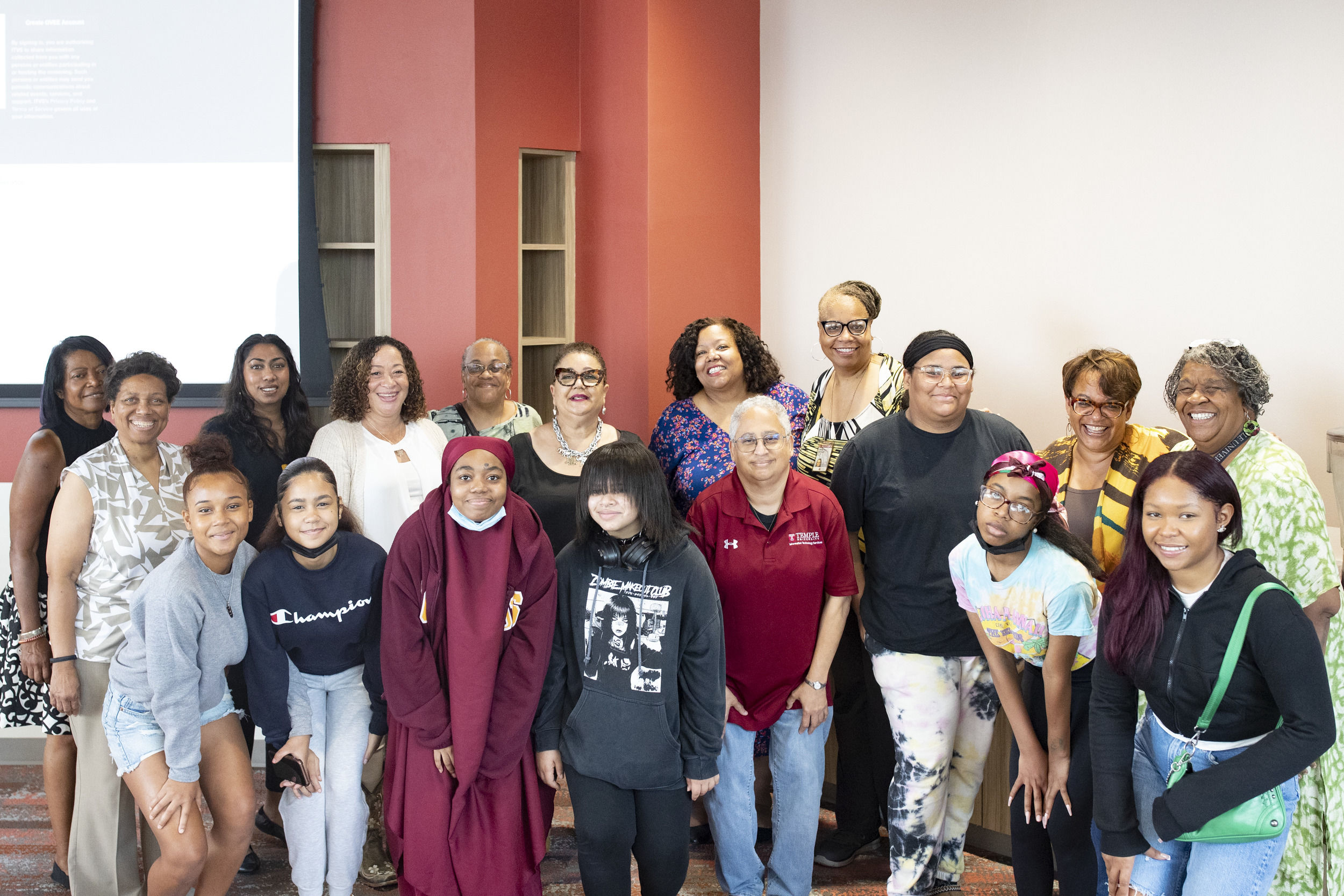 A group of about 20 people stand together and pose for a picture.