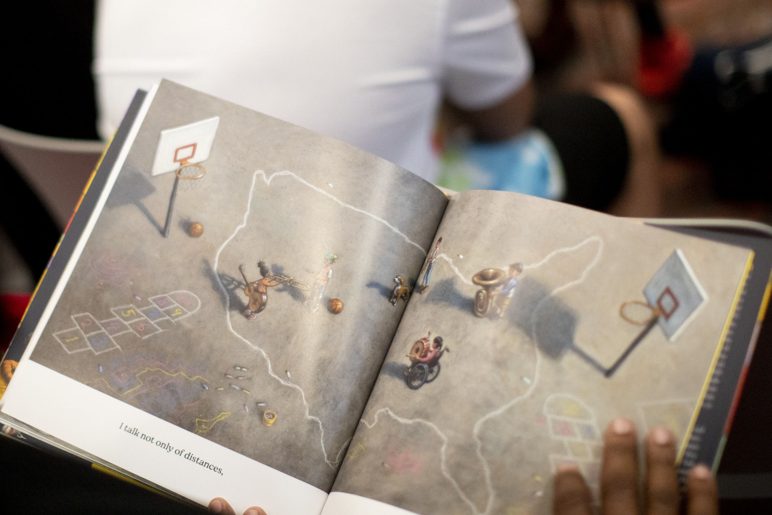 A book is open and held in the lap of a young reader.